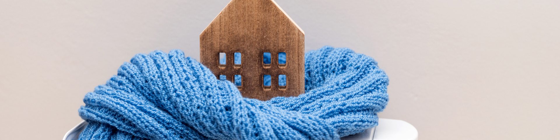 Miniatuurhuisje met sjaal op radiator