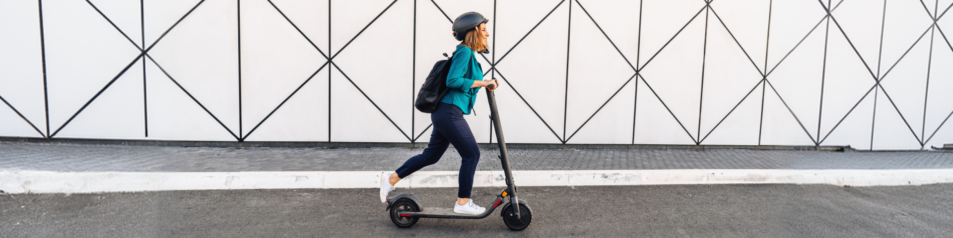 Foto van een vrouw van middelbare leeftijd die op een elektrische scooter naar haar werk rijdt.
